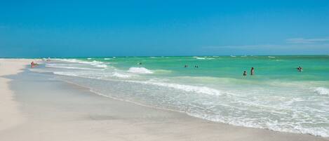 A beach with clear turquoise water and a sandy shore.