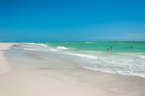 Una playa cerca, sillas reclinables de playa, toallas de playa