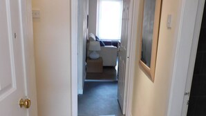 A hallway leading to a living area with a sofa, a lamp, and a painting on the wall. - Fabulous location, One Bedroom West End Flat, just off Byres rd, close to SEC & Hydro (Glasgow)