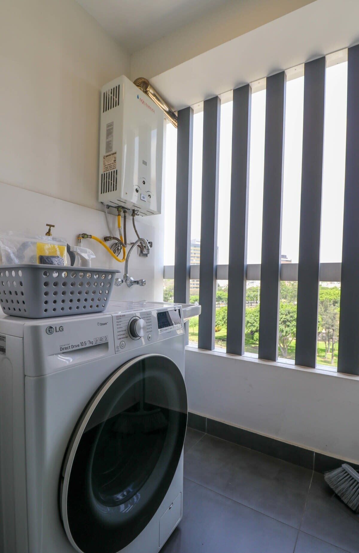 A laundry area with a front-loading washing machine, a dryer, and a water heater.