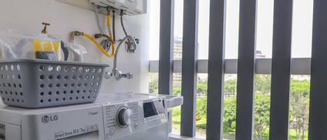 A laundry area with a front-loading washing machine, a dryer, and a water heater.