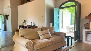 Un canapé en cuir beige avec un coussin, une table basse en bois et un mur en briques au style rustique.