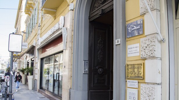 Un bâtiment doté d’une grande porte noire, d’une enseigne indiquant « Studio Tecnico » et d’une plaque portant le nom « Gianni Donetti Notte ».