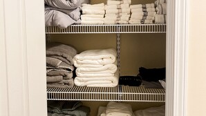 A closet with multiple shelves containing folded towels and pillows. - Cottage 304, 2 Bed w/ Fire Pit, near trails! (West Logan)