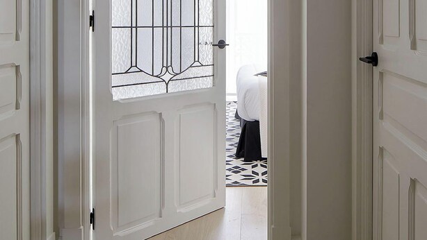A hallway with a white door featuring a decorative glass panel. The hallway has a light-colored wooden floor and white walls. - Erregetxe by FeelFree Rentals (San Sebastián)