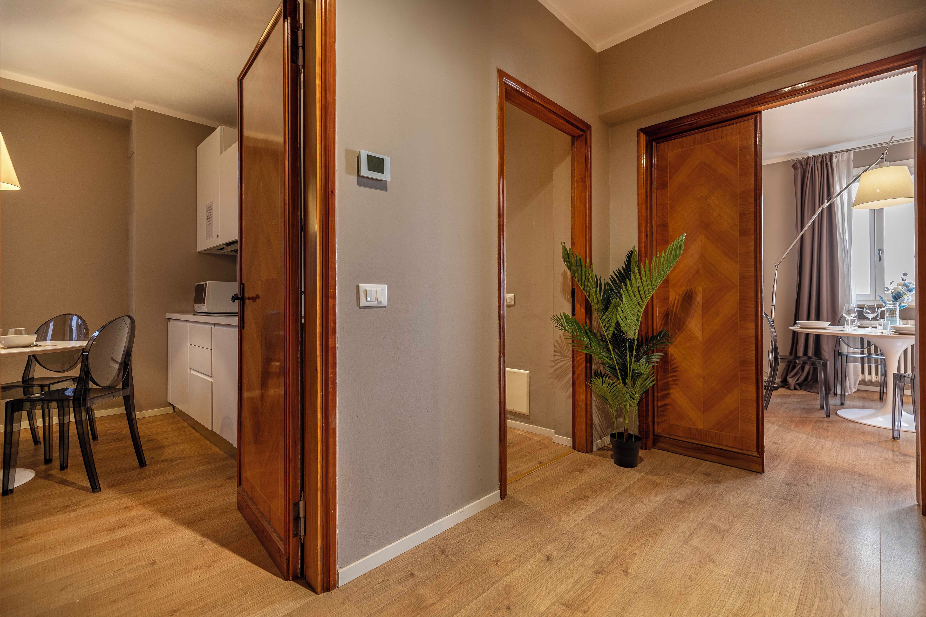 Eine moderne Küche mit Essbereich, Holzboden und einem Blumentopf.