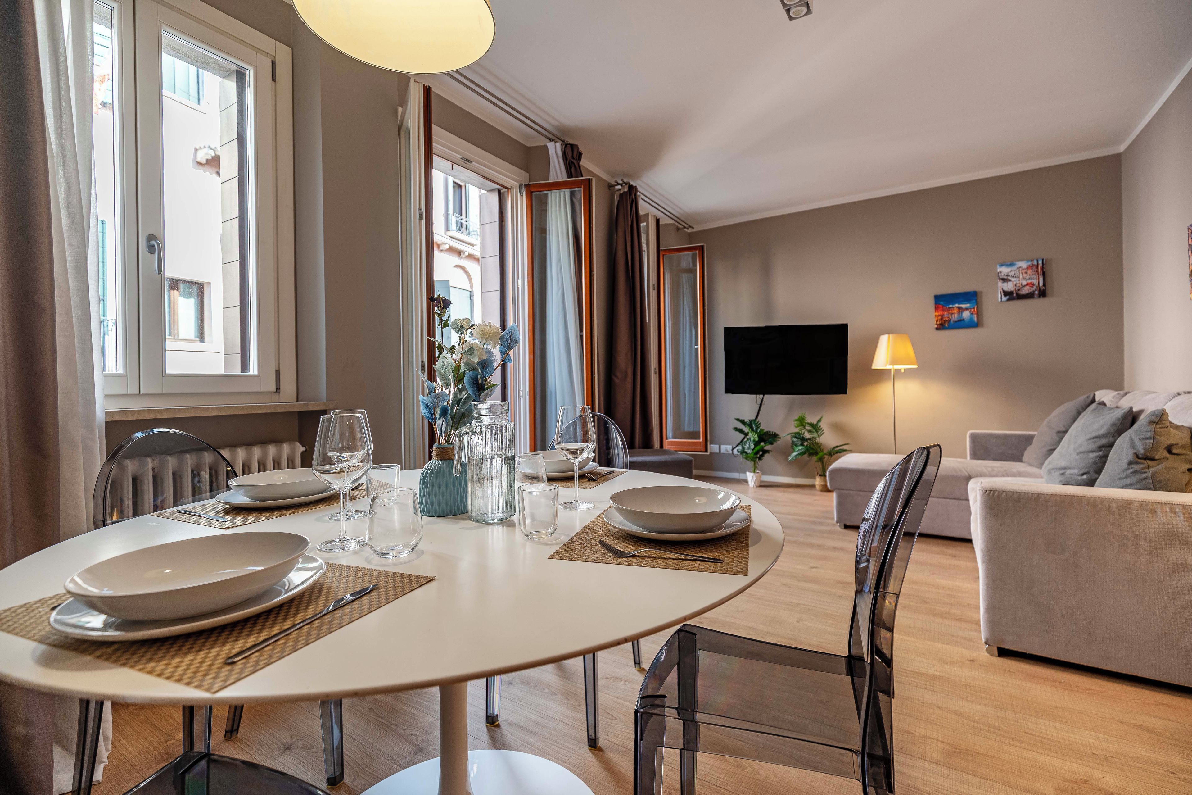 Una sala moderna con comedor, televisor de pantalla plana y sofá.