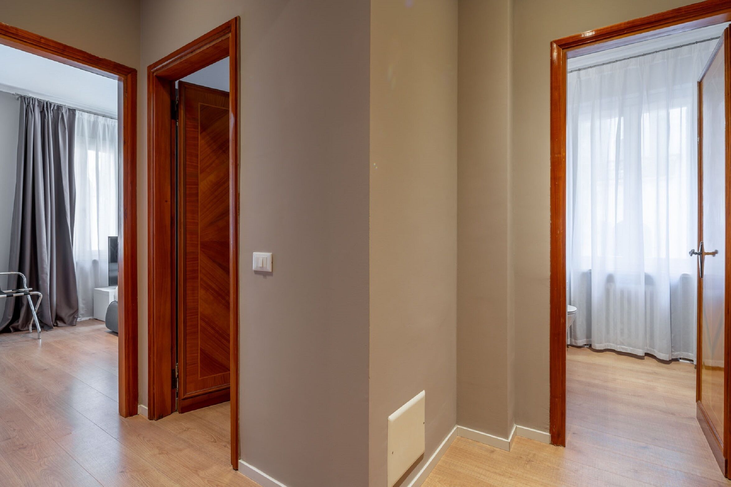 A hallway with wooden doors, a radiator, and a chair.