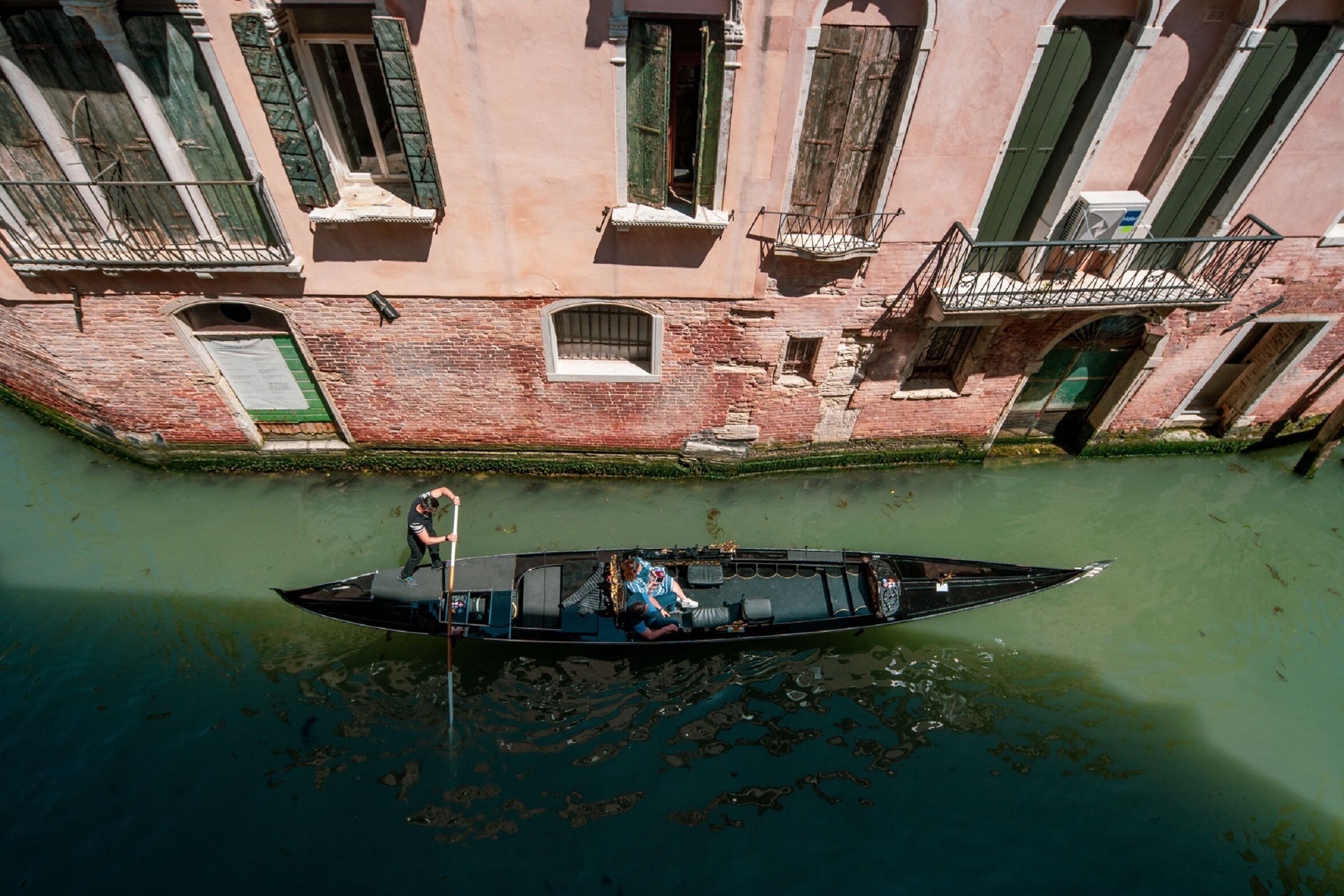 A narrow canal with a boat carrying two passengers.