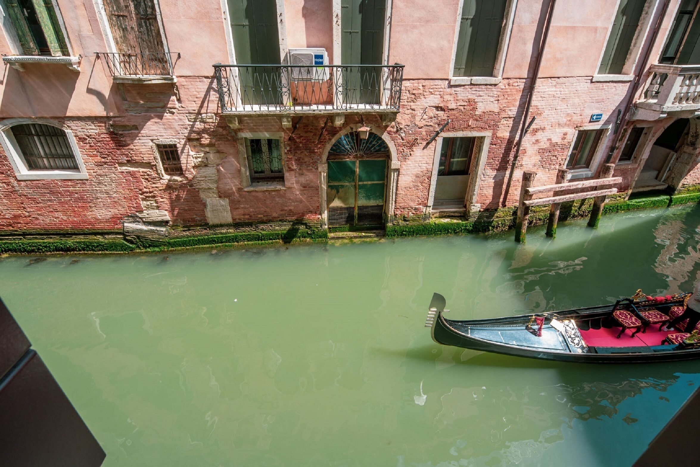A canal with a gondola, buildings with balconies, and a clear view of the water.