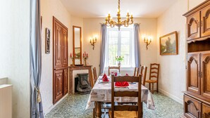 Comedor con candelabro, muebles de madera y una ventana con cortinas.