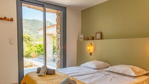 Une chambre à coucher avec un lit, une fenêtre et une vue sur un patio.