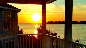 A balcony with a view of a sunset over a body of water. - Sunrise-Sunset Views From Waterfront Home w/ Elevator (just renovated) (Bethany Beach)
