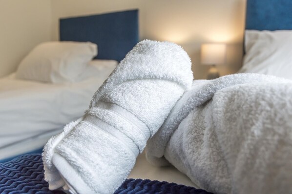 A bed with white bedding and a blue headboard.