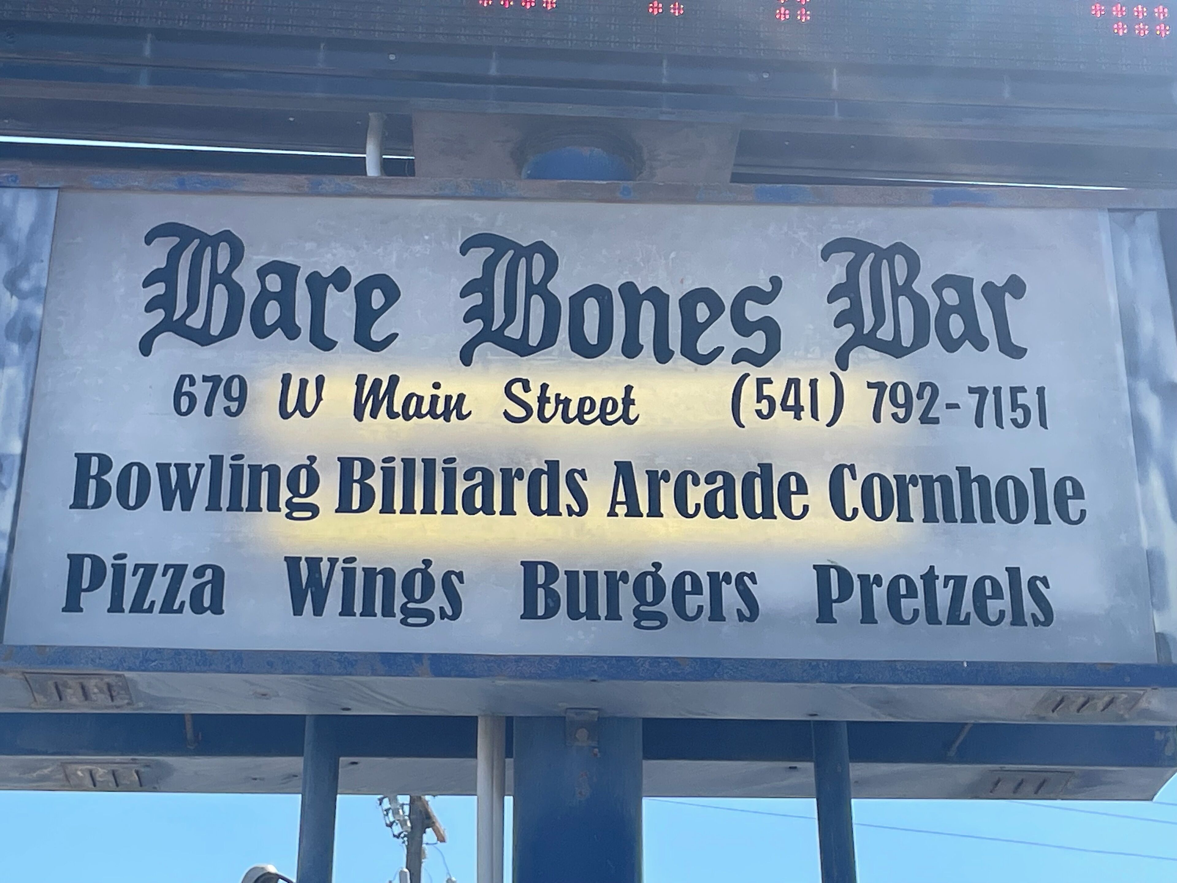 Señal de Bare Bones Bar, ubicado en 679 W Main Street, que ofrece bolos, billares, juegos de arcade, lanzamiento de aros, pizza, alitas, hamburguesas y pretzels.