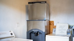 A compact kitchen with a stainless steel refrigerator, a built-in oven, and a coffee maker. - Budget 8 Motel John Day (John Day)