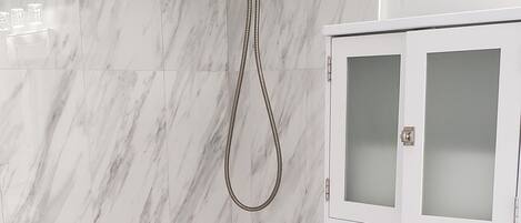 Une salle de bain avec une baignoire blanche, des toilettes et un meuble avec des portes en verre dépoli.