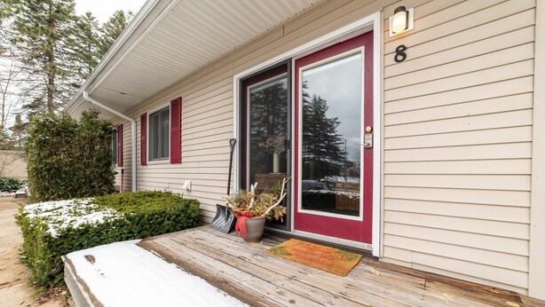 A house with a red door, a number 8 sign, a wooden porch, and a doormat. - Awesome in Walloon Village (Walloon Lake)