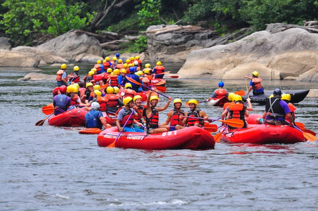 Eine Gruppe von Menschen in roten Luftmatratzen auf einem Fluss.