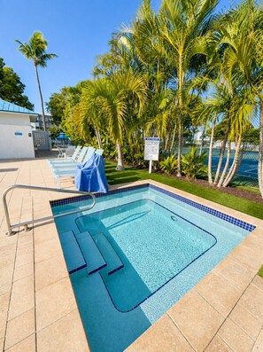 A swimming pool with lounge chairs and palm trees. - 4 Flr |2 Mastr |Oceanview |Jacuzzi |Beach |Marina (Tavernier)