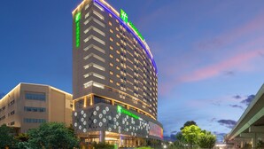 A high-rise hotel with a modern design, featuring a prominent 'H' logo on the facade. - Holiday Inn Express Chongqing Airport Zone by IHG (Chongqing)