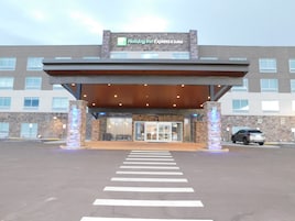 Un Holiday Inn Express & Suites con entrada techada, un paso de peatones y un estacionamiento.