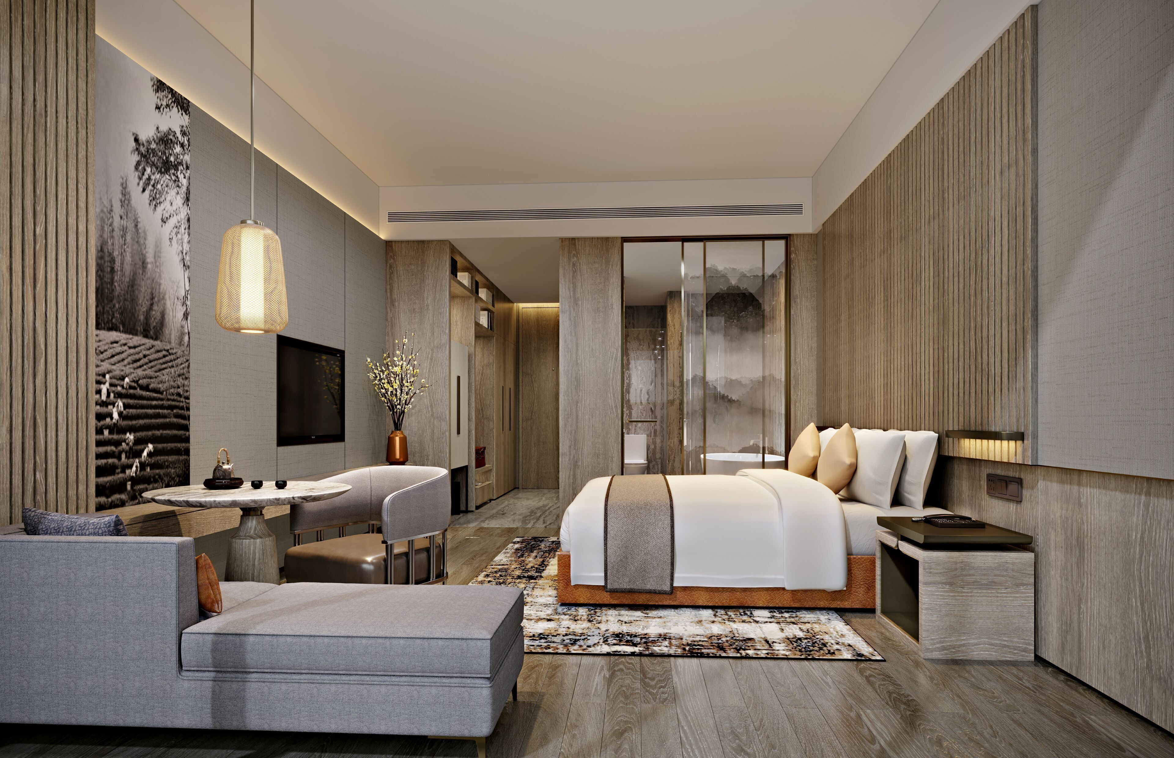 Une chambre moderne avec un grand lit, un bureau et un coin salon.