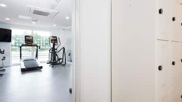 Een moderne sportschool met trainingsapparatuur, een loopband en een hometrainer.