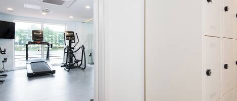 A modern gym with exercise equipment, a treadmill, and a stationary bike.