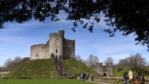 A historic castle with a prominent tower, surrounded by a grassy area and trees. - Staybridge Suites Cardiff by IHG (Cardiff)