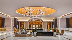 A spacious lobby with a central seating area, a reception desk, and a decorative ceiling. - Holiday Inn Resort Ho Tram Beach by IHG (Ho Chi Minh City)