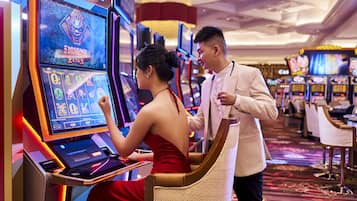 Un casino con máquinas tragamonedas y una mujer jugando.