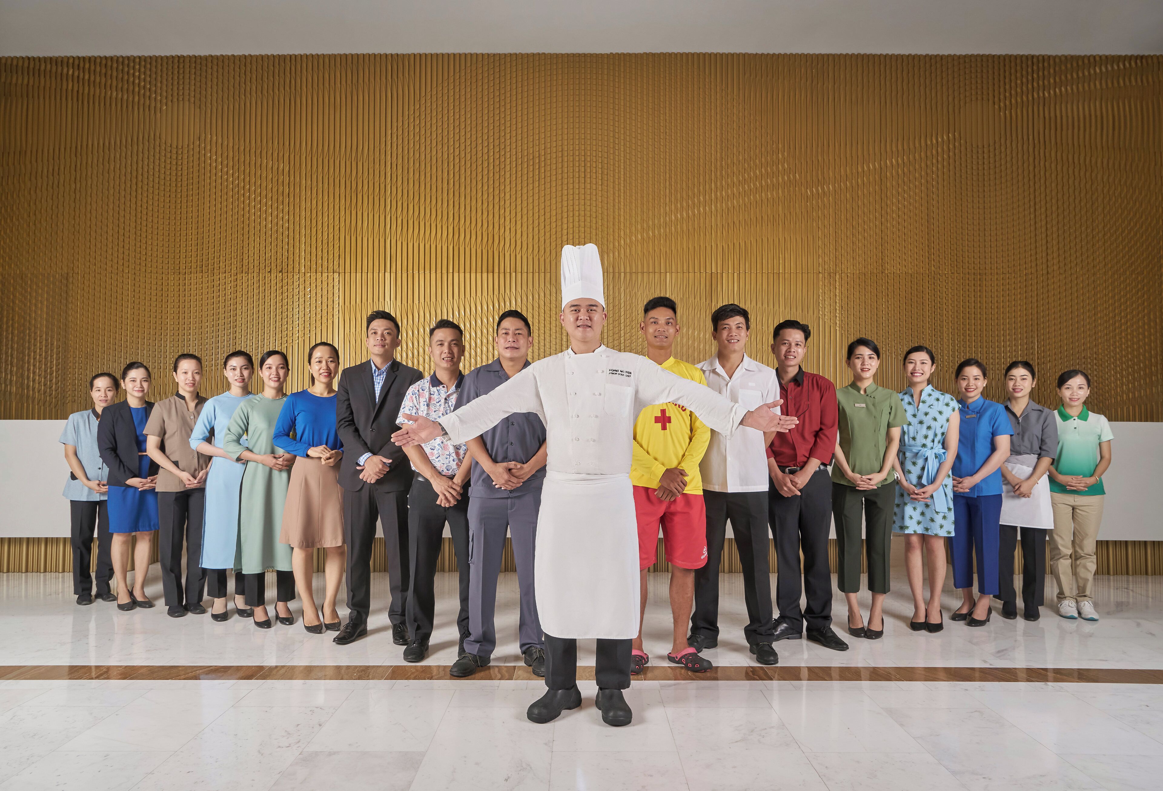Un grupo de personas hacen fila mientras un chef está al frente.