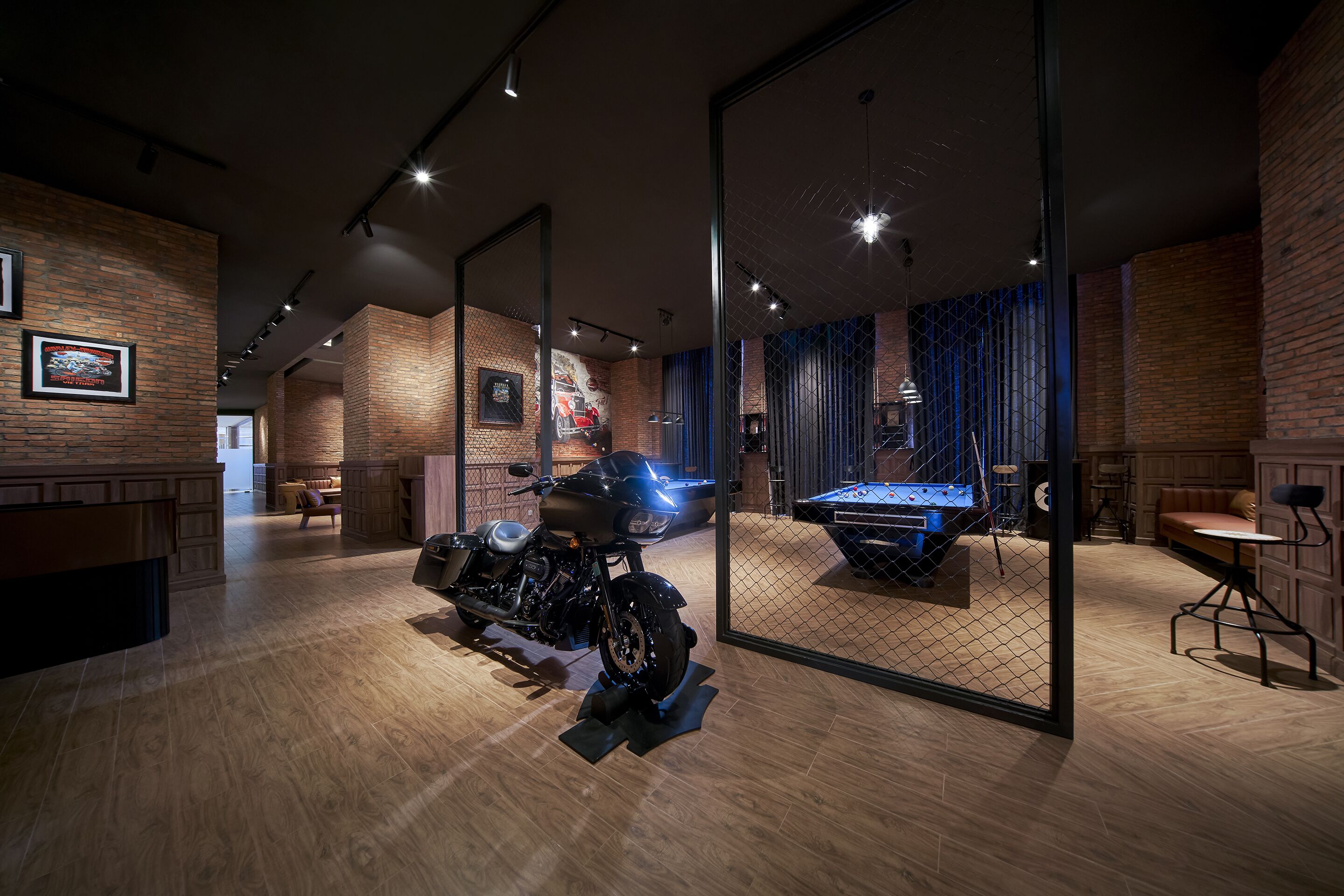 Un intérieur moderne avec une exposition de motos, un plancher en bois et des murs en briques.