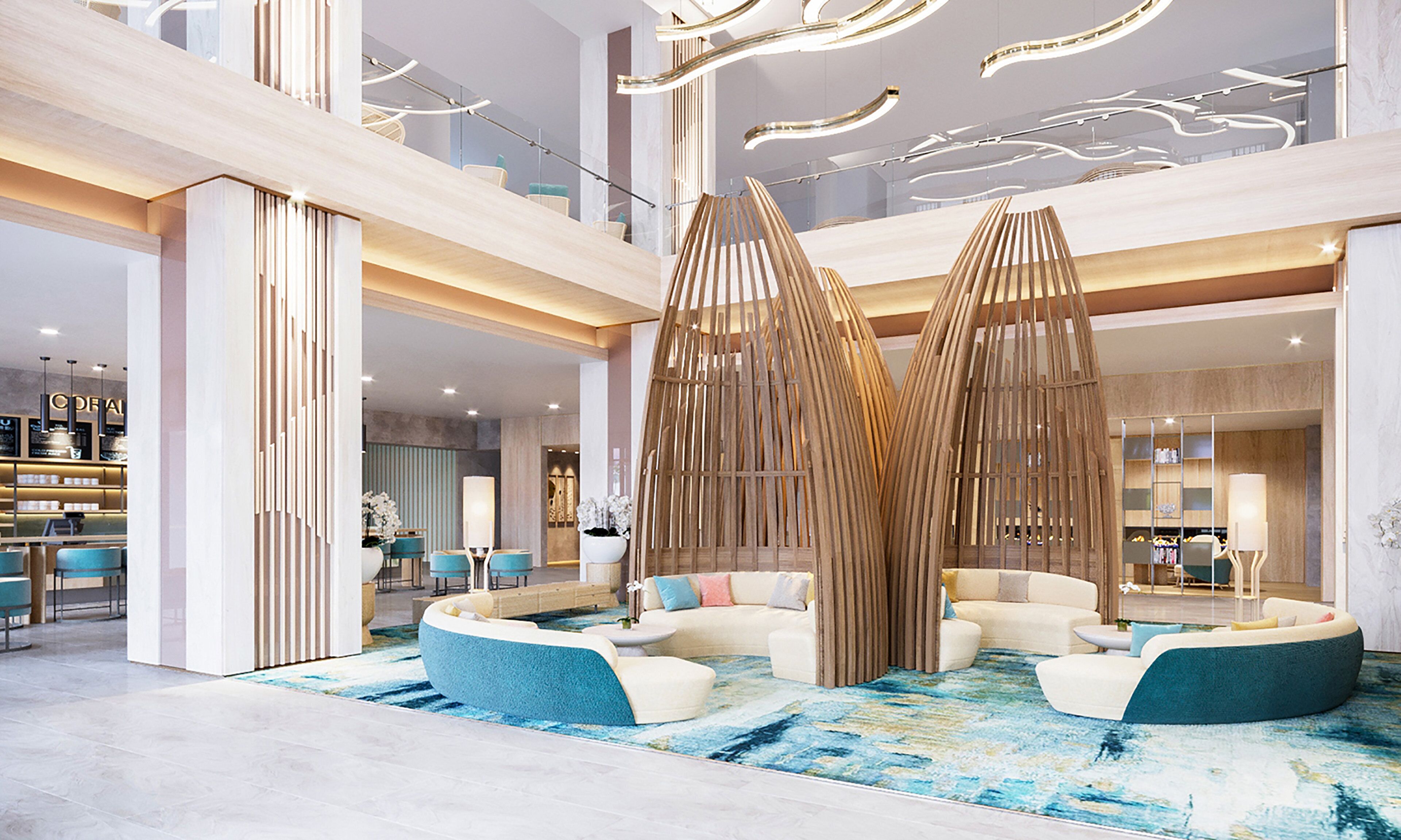A modern lobby with a central seating area, a bar, and a staircase.