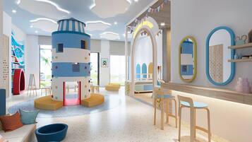Children can play and learn in this vibrant play area with a striped play structure, bookshelves, and seating area.