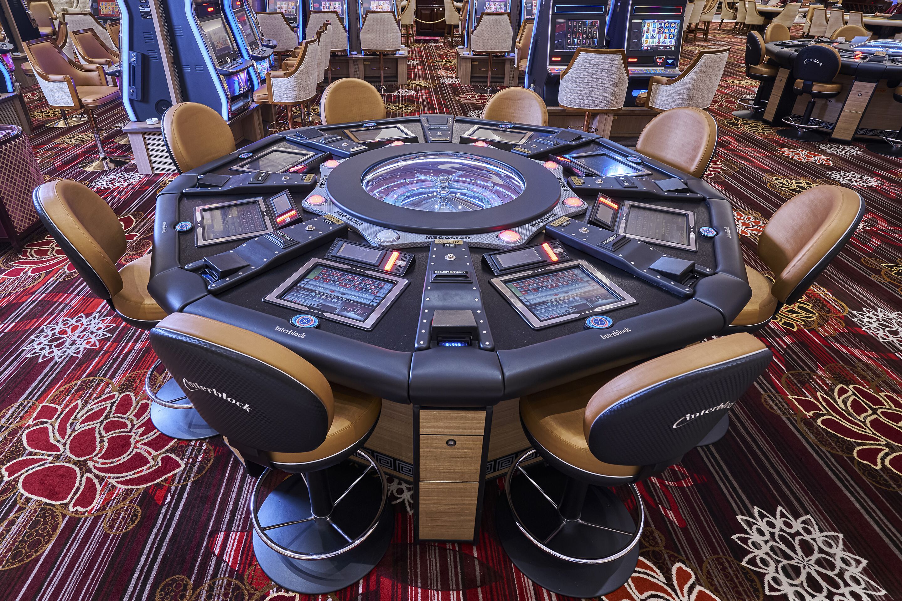 Une table de jeu ultramoderne dotée de plusieurs écrans et de commandes, entourée de fauteuils en cuir.