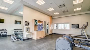 Un gimnasio moderno con cintas de correr, mancuernas y equipamiento de ejercicio.