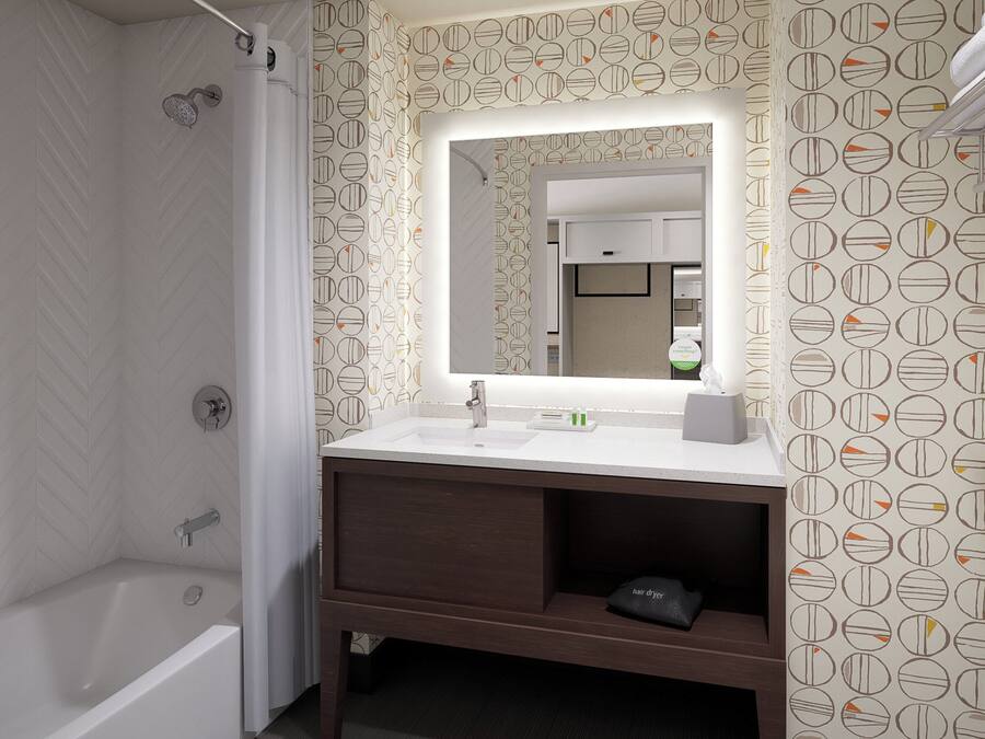 A bathroom with a shower, a sink with a mirror, and a towel rack.