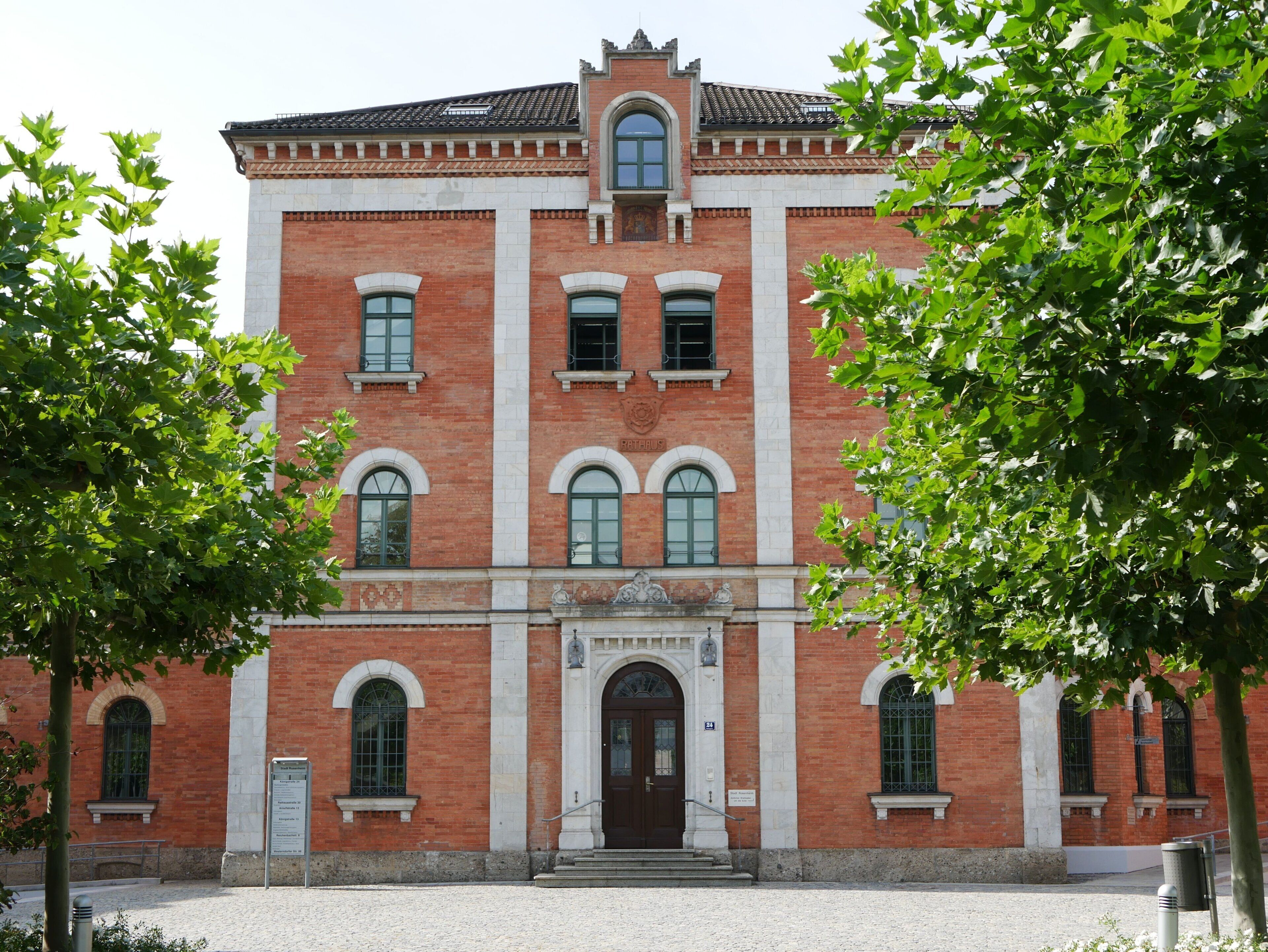 Ein rotbackstein Gebäude mit einer symmetrischen Fassade, gewölbten Fenstern und einem zentralen Eingang mit Stufen.