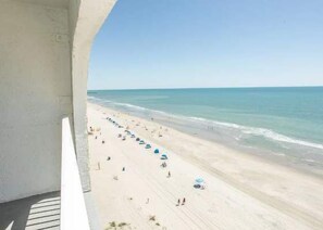 Blick auf den Strand vom Balkon aus, bewölkter Himmel.