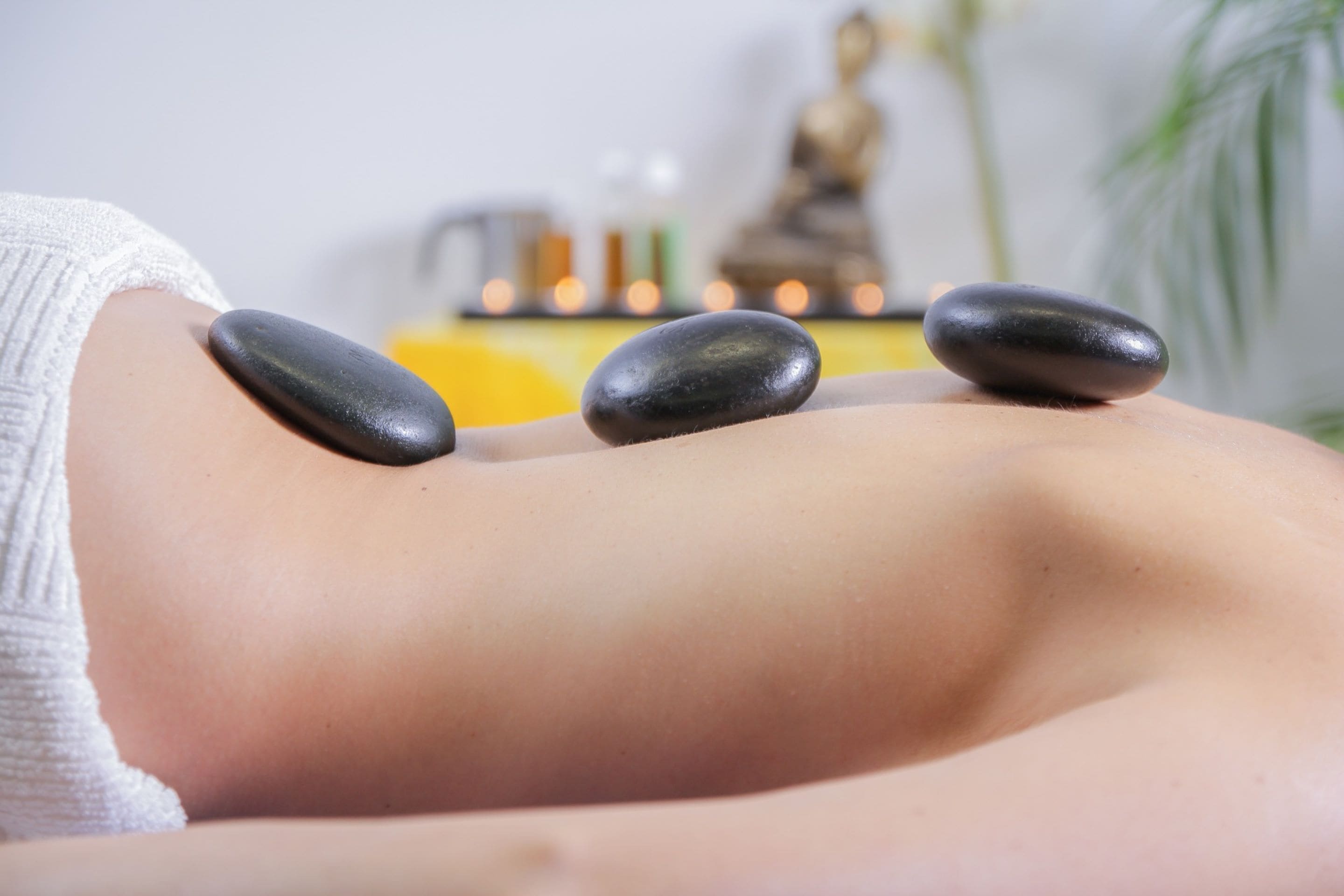 A massage therapy session with stones on a client's back.