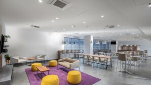 A modern office space with a reception area, meeting rooms, and a dining area.