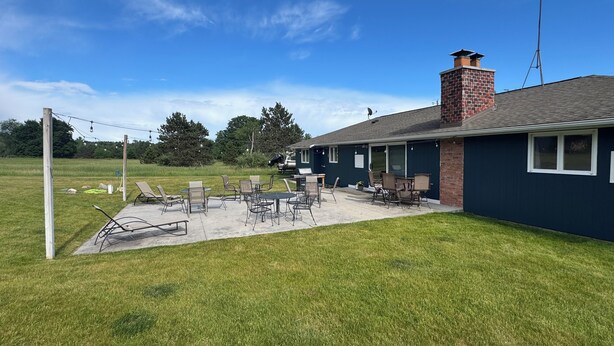A house with a patio area featuring outdoor furniture and a grill.