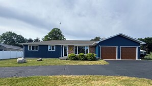 A single-story house with a garage, a front porch, and a lawn.