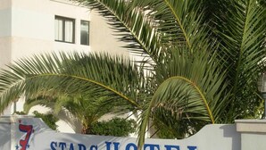 Placa do Stars Hotel com palmeiras ao fundo.