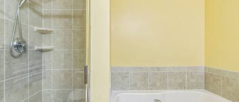 A bathroom with a shower, a bathtub, and a toilet.