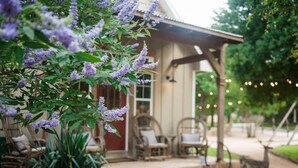 Ein überdachter Außenbereich mit Korbmöbeln und einer Holzpergola.