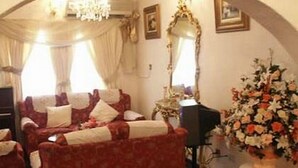 Una habitación con un sofá rojo, un piano y un arreglo floral.