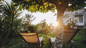 Two outdoor chairs under a tree with a building in the background. - Balcony at Arousa - Upscale Getaway + Patio (Villagarcía de Arosa)
